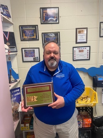 Mora boys basketball head coach Curt Grachek with his Minnesota Basketball Coaches Association 2021-2022 Class 6AA Section Coach of the Year award. Photo by Nick Hoffman.